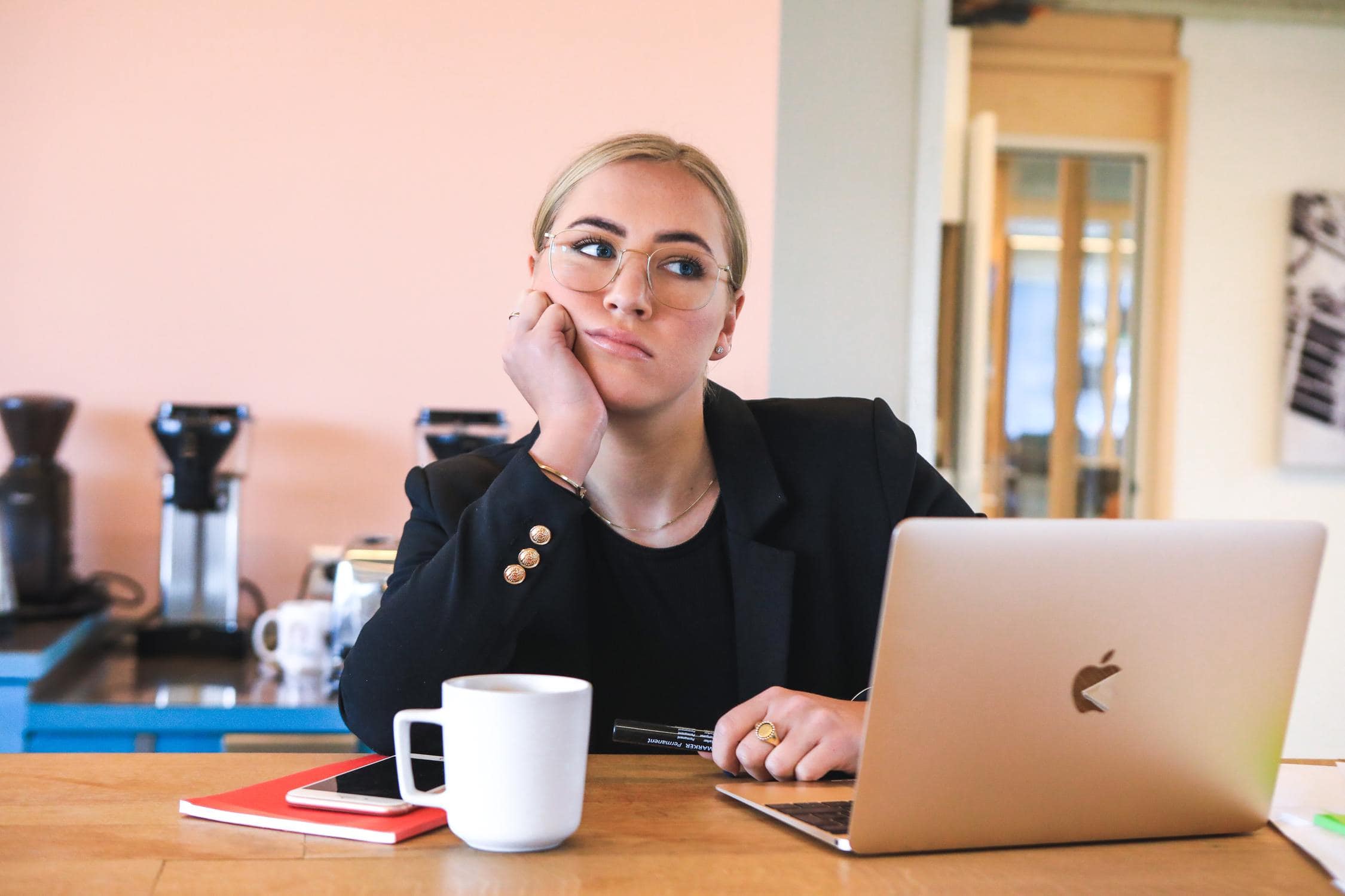 Junge Frau, die vor Laptop sitzt und das Gesicht besorg verzieht