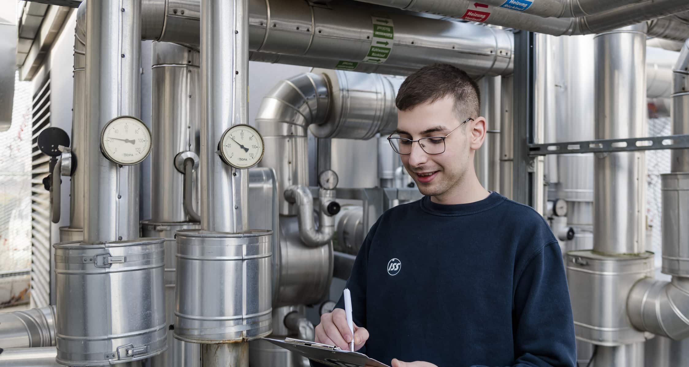 Elektro- und Gebäudetechniker vor einer Anlage