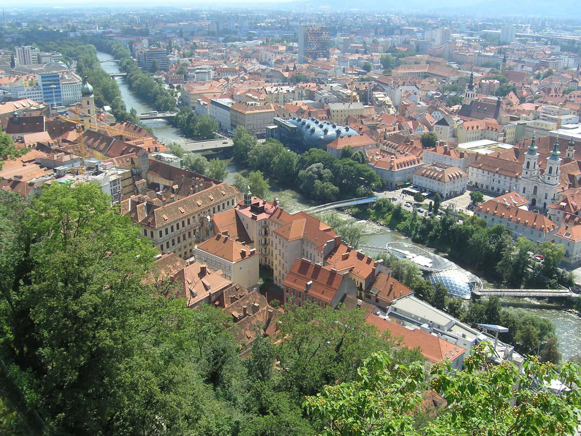Graz, fotografiert aus der Luft, mit Fokus auf die Mur, die durch die Stadt fließt