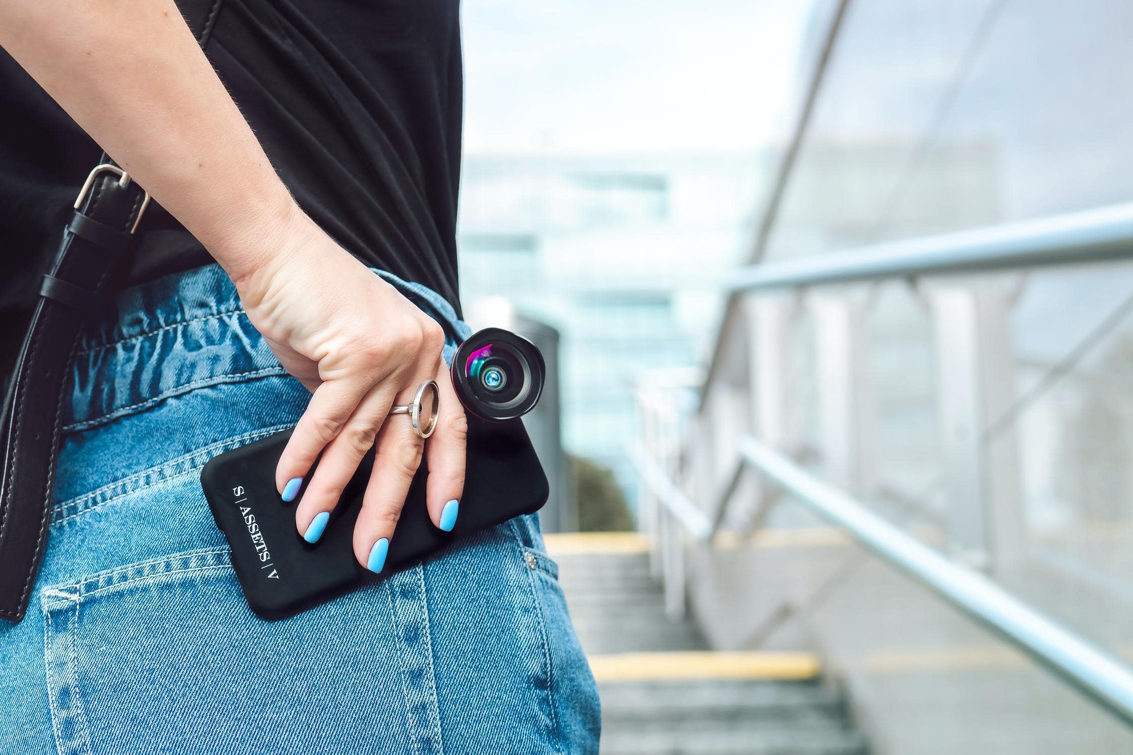 Junge Frau hat eine zusätzliche Kamera an ihrem Handy befestigt, um das perfekte Video zu drehen