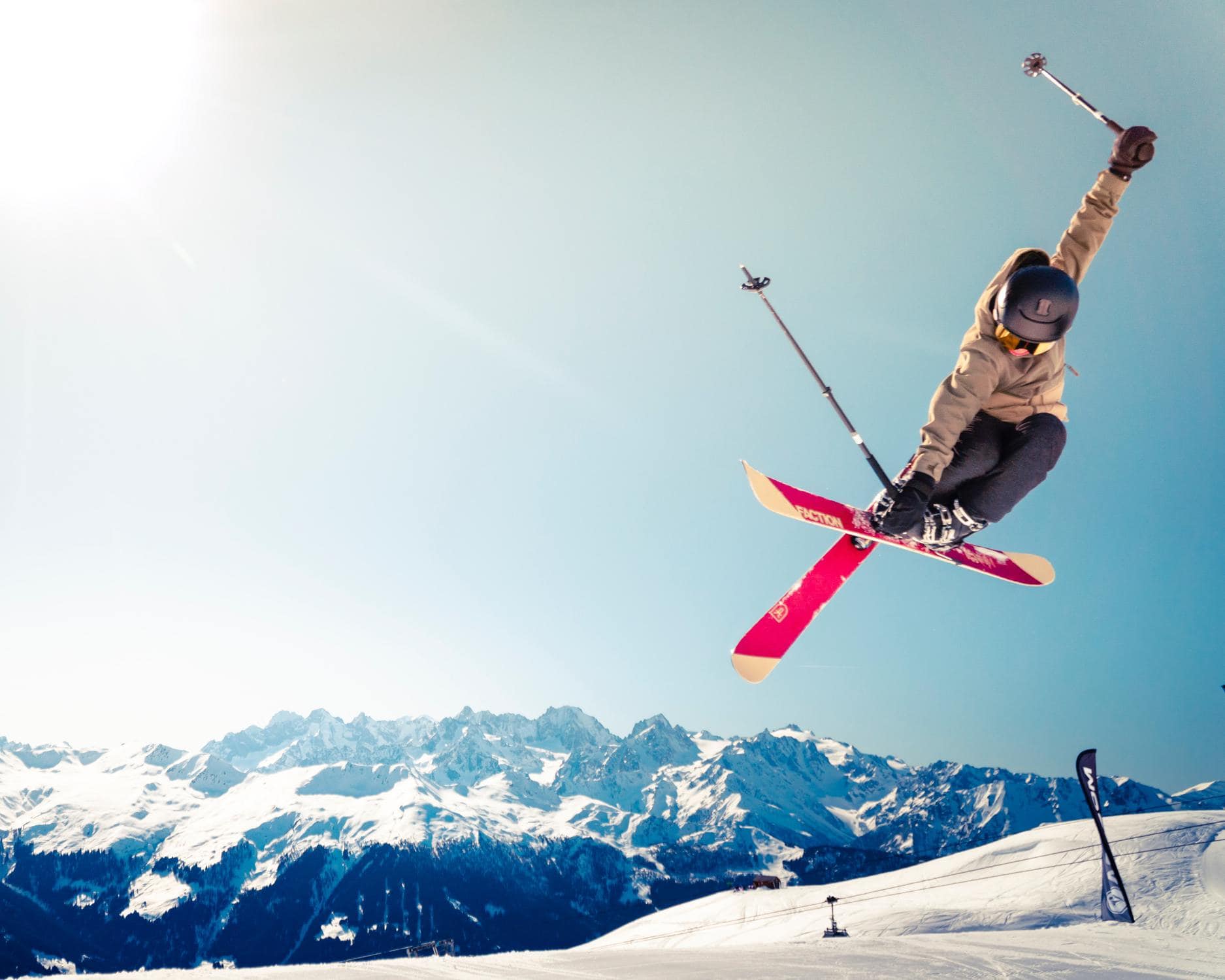 Tricksprung einer skifahrenden Person im Schnee als Beispiel für Wintersport