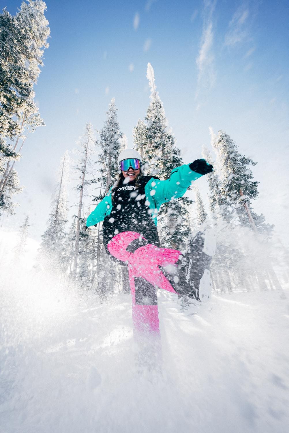 Junge Frau in Wintersport-Kleidung hat Spaß im Schnee