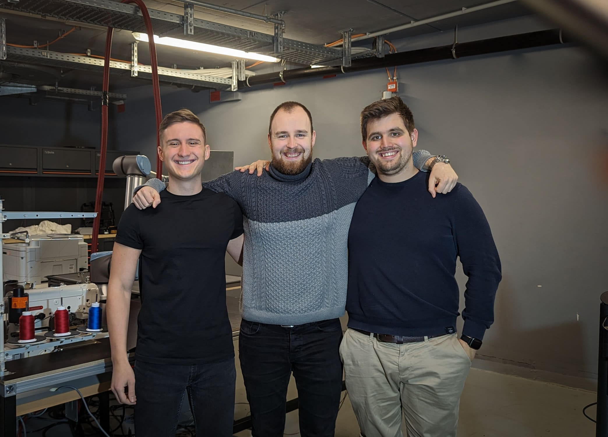 Das Team des Start-ups silana, drei junge Männer, stehen arm in arm nebeneinander.