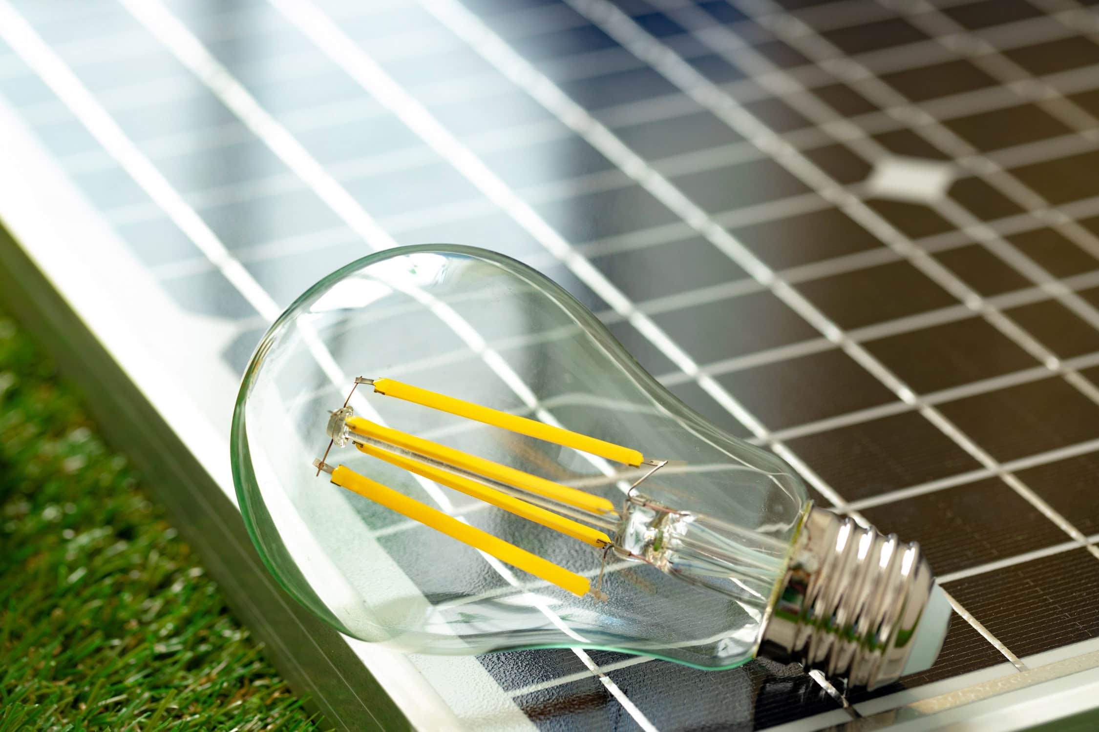 Glühbirne liegt auf einem Solarpanel.