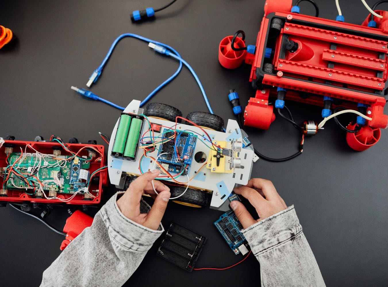 Kinderhände, die an einem Roboter herumwerkeln