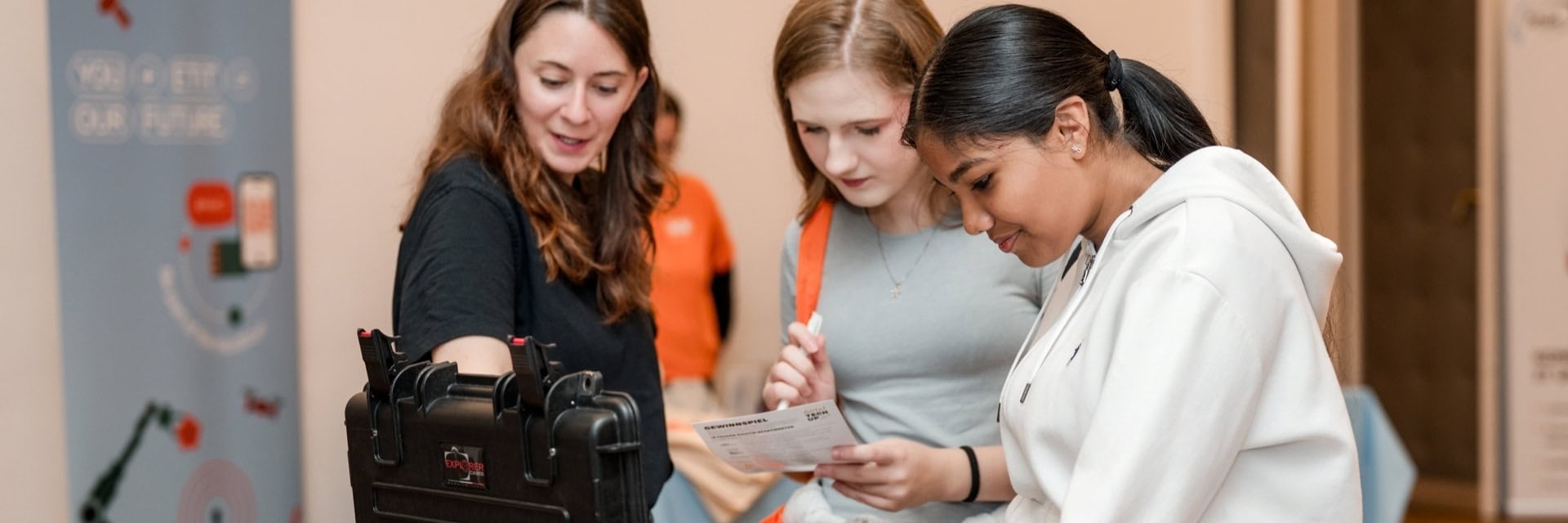 Zwei Schülerinnen mit einer Standbetreuerin vor einem Baukasten bei Girls! TECH UP Wien 2026